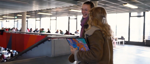 Zwei fröliche Studentinnen in der Uni